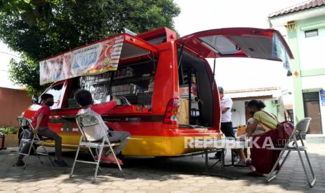 Anak-anak memanfaatkan layanan Mobil Internet dan Layanan Kewilayahan (Monika) milik Perpustakaan Kota Yogyakarta di Demangan, Yogyakarta, Rabu (2/6). Di Monika anak-anak bisa memanfaatkan layanan internet gratis menggunakan laptop. Selain itu, juga bisa membaca buku atau bermain bersama. Layanan ini mendatangi masyarakat dua kali dalam sehari, biasanya di tempat fasilitas umum.