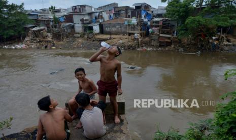 Anak-anak beraktivitas di bantaran sungai Ciliwung, Manggarai, Jakarta, Senin (16/1/2023). BKKBN sebut seharusnya sudah tidak ada warga mengalami miskin ekstrem di Jakarta.