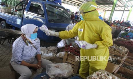 Petugas medis mengukur suhu tubuh seorang pedagang dalam tes cepat atau rapid test di Pasar Karangploso, Malang, Jawa Timur (ilustrasi)