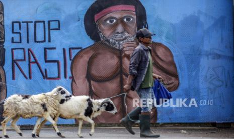 Warga melintas di depan mural bertema Anti Rasisme  di Jalan Raya Bogor, Cilodong, Depok, Jawa Barat,  Selasa (28/7/2020). Mural tersebut dibuat untuk mengkampanyekan gerakan anti rasisme serta sebagai media edukasi masyarakat . ANTARA FOTO/Yulius Satria Wijaya/hp.