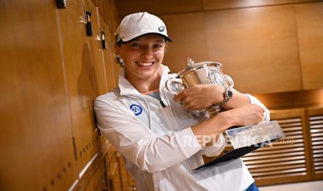 Foto selebaran yang disediakan oleh FFT Federasi Tenis Prancis menunjukkan Iga Swiatek dari Polandia berpose dengan Piala Suzanne-Lenglen di ruang ganti putri Prancis Terbuka setelah memenangkan pertandingan final tunggalnya melawan Coco Gauff dari Amerika Serikat di Roland Garros, Paris, Prancis , 4 Juni 2022.