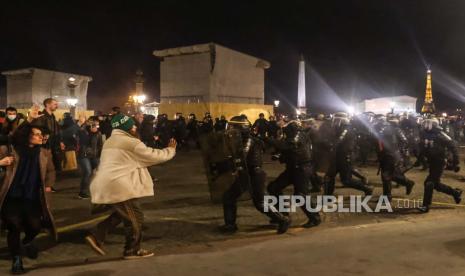  Petugas polisi berlari selama demonstrasi di dekat Majelis Nasional setelah pemungutan suara Majelis Nasional Prancis pada undang-undang reformasi pensiun yang diusulkan pemerintah, di Paris, Prancis, Kamis (16/3/2023). Orang-orang berdemonstrasi di luar Parlemen Prancis setelah Perdana Menteri Prancis Borne mengajukan Pasal 49 paragraf yang kontroversial 3 (49.3) Konstitusi untuk mengesahkan undang-undang reformasi pensiun yang akan menaikkan usia pensiun dari 62 menjadi 64 tahun pada tahun 2030 setelah Senat memberikan suara setuju.