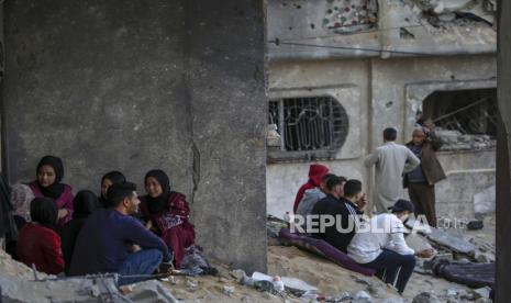 Warga Palestina duduk di tengah puing-puing rumah keluarga mereka yang hancur, menyusul serangan Israel di kota Beit Lahiya, Jalur Gaza utara, 14 Mei 2023. Gerakan Israel dan Jihad Islam menyetujui gencatan senjata yang ditengahi Mesir pada akhir 14 Mei. Israel telah melakukan beberapa serangan terhadap pimpinan militer gerakan Jihad Islam Palestina, sebagai pembalasan atas roket yang ditembakkan ke Israel dari Jalur Gaza.