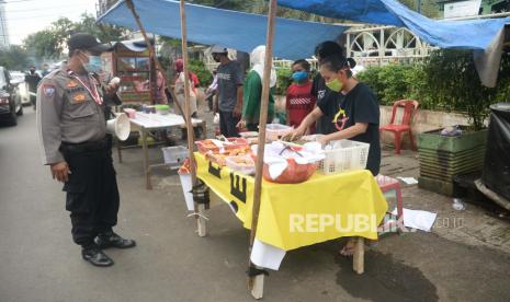 Anggota Polisi memberikan himbauan kepada para pembeli dan pedagang makanan berbuka puasa atau takjil agar tetap menjaga jarak serta wajib mengunakan masker.