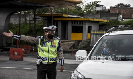 Petugas kepolisian mengarahkan kendaraan untuk memutar balik di pos pemeriksaan Pembatasan Sosial Berskala Besar (PSBB) - ilustrasi