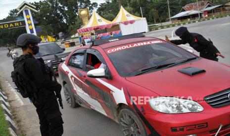 Personel Brimob Polda Sultra mengimbau pengendara untuk mengenakan masker dan tidak melakukan mudik Lebaran di areal perbatasan Kabupaten Konawe Selatan dan Kendari, Kendari, Sulawesi Tenggara, Minggu (10/5/20). Pemerintah Kota Kendari bersama Kabupaten Konawe Selatan melakukan pendataan warga yang masuk dan keluar menjelang dua pekan Hari Raya Idul Fitri 1441 H  di pintu perbatasan dan mengimbau pengendara untuk tidak mudik lebaran untuk mengantisipasi penyebaran  COVID-19