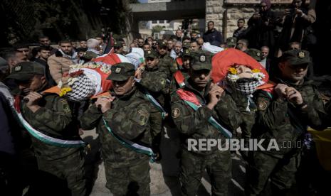  Petugas polisi Palestina membawa jenazah Yazan Khaseeb (kanan) dan Sefian al-Khawaja (kiri) saat pemakaman mereka, di kota Ramallah, Tepi Barat, Sabtu (18/3/2023). Pasukan Israel menembak mati Khaseeb pada 17 Maret setelah dia diduga mencoba menusuk seorang tentara. Al-Khawaja dibunuh oleh pasukan Israel di dekat pemukiman Yahudi di desa Nilin di Tepi Barat pada tahun 2020 dan jenazahnya dikembalikan untuk dimakamkan pada hari Jumat.