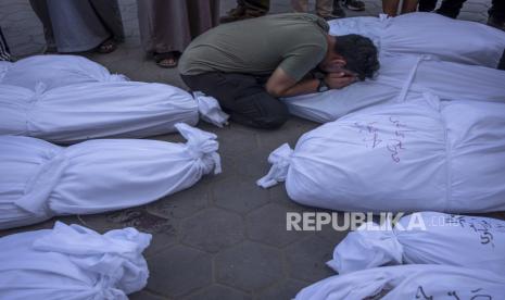 Warga Palestina berduka atas kerabat mereka yang meninggal dalam pemboman Israel di Jalur Gaza, di depan kamar mayat di Deir al Balah, Selasa, (31/10/2023).