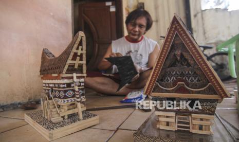 Perajin membuat kerajinan lampu hias berbentuk rumah adat di Mienani Craft, Depok, Jawa Barat, Jumat (3/9). Bank Indonesia (BI) mewajibkan perbankan untuk memenuhi rasio pembiayaan inklusif makroprudensial (RPIM) UMKM sebesar 20 persen pada Juni 2022.