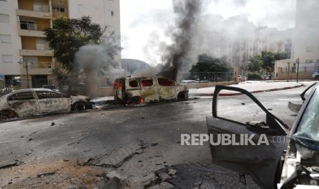 Mobil hancur dan bangunan rusak di Kota Ashkelon, Israel, setelah peluncuran roket dari Gaza, Sabtu (7/10/2023). Rentetan roket diluncurkan dari Jalur Gaza dalam serangan yang diklaim oleh Hamas. 