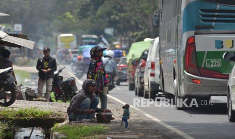 Rongeng monyet mengais rezeki di tengah kepadatan lalu lintas.