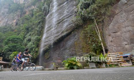 Pengunjung bersepeda di objek wisata Lembah Harau, Kabupaten Limapuluhkota, Sumatra Barat.