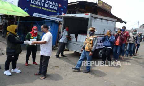 Relawan membagikan nasi bungkus dan masker gratis untuk masyarakat dalam Gerakan Nasi Bungkus (Gasibu) di Terminal Dago, Jl Ir H Djuanda, Kota Bandung, Ahad (19/4). Kegiatan tersebut untuk membantu masyarakat yang terdampak Covid-19