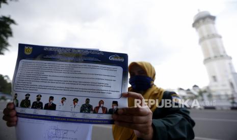 Personel Wilayatul Hisbah (Polisi Syariat Islam) Kota Banda Aceh memperlihatkan seruan bersama larangan perayaan pergantian tahun masehi di Banda Aceh, Aceh, Selasa (22/12/2020). Forum Komunikasi Pimpinan Daerah (Forkopimda) Kota Banda Aceh mengeluarkan seruan bersama agar tidak merayakan pergantian tahun masehi dari 2020 ke 2021 dengan pesta kembang api, mercon, meniup terompet dan kegiatan lain yang bertentangan dengan Syariat Islam serta adat istiadat masyarakat Aceh. 