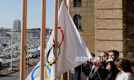 Walikota Marseille Benoit Payan, tengah, mengibarkan bendera Olimpiade bersama Ketua Olimpiade Paris 2024 Tony Estanguet, kanan tengah, usai konferensi pers di Balai Kota Marseille, Prancis selatan, Jumat, 3 Februari 2023. Alih-alih tiba lewat darat, api simbolis yang turun pada Olimpiade Paris 2024 akan dibawa ke laut dari tempat kelahirannya di Yunani, tiba dengan kapal tinggi bertiang tiga di pelabuhan Prancis di Marseille.