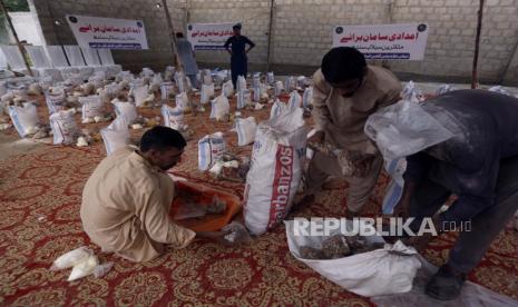 Para pria menyiapkan jatah makanan gratis yang disumbangkan oleh Naiki Foundation untuk orang-orang yang terkena dampak banjir, di Karachi, Pakistan, Minggu, 28 Agustus 2022. Para pejabat di Pakistan mengatakan kematian akibat banjir yang meluas telah mencapai 1.000 sejak pertengahan Juni. Banjir bandang akibat hujan lebat telah menghanyutkan desa-desa dan tanaman ketika tentara dan pekerja penyelamat mengevakuasi penduduk yang terdampar ke kamp-kamp bantuan yang aman dan menyediakan makanan bagi ribuan orang Pakistan yang terlantar.