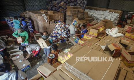 Pekerja mengemas sembako bantuan sosial (bansos)  di gudang distribusi, Dramaga, Kabupaten Bogor, Jawa Barat, Rabu (29/4/2020). Pemerintah Provinsi Jawa Barat menyalurkan bansos senilai Rp500 ribu bagi warga yang berpenghasilan rendah dan termasuk miskin baru akibat pandemi COVID-19