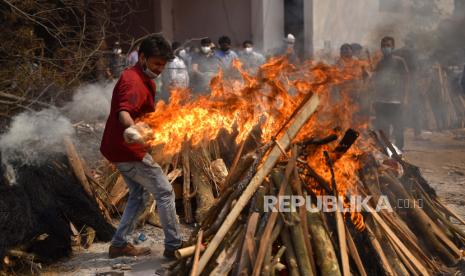  Kerabat melakukan upacara terakhir untuk korban COVID-19 selama pemakaman mereka di tempat kremasi di New Delhi, India,  Kamis (29/4). Delhi melaporkan 25.986 kasus baru, 368 kematian dalam 24 jam terakhir dan terus berjuang dengan pasokan oksigen.