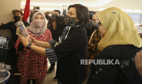 Menteri Keuangan Sri Mulyani (tengah), didampingi oleh Direktur Eksekutif Lembaga Pembiayaan Ekspor Indonesia (LPEI) Rijani Tirtoso (kanan) meninjau produk UMKM Binaan LPEI. Indonesia memegang Presidensi G20 selama satu tahun yang dimulai sejak 1 Desember 2021 sampai November 2022 dengan mengangkat tema Recover Together, Recover Stronger. Lembaga Pembiayaan Ekspor Indonesia (LPEI)/ Indonesia Eximbank sebagai Special Mission Vehicle (SMV) Kementerian Keuangan, berpartisipasi pada acara penyambutan G20 yang digelar di Bali sejak 13 sampai 17 Juli 2022.