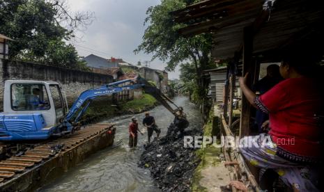 Petugas mengoperasikan alat berat saat melakukan pengerukan di Kali Mampang, Pondok Jaya, Jakarta Selatan.