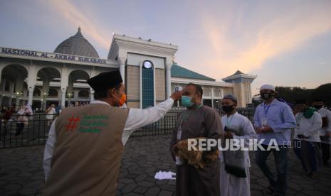 Masjid Al-Akbar Surabaya Tetap Gelar Sholat Idul Fitri. Foto: Petugas memeriksa suhu tubuh jamaah sebelum pelaksanaan shalat Idul Adha di Masjid Al Akbar, Surabaya, Jawa Timur, Jumat (31/7/2020). Pelaksanaan shalat Idul Adha di masjid tersebut menerapkan protokol kesehatan secara ketat seperti pengecekan suhu tubuh, penggunaan masker, pengaturan jarak serta pengurangan jumlah jamaah yang biasanya mencapai 40.000 orang menjadi 5.000 jamaah. 