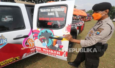 Anggota polisi Polres Kediri Kota menyiapkan mobil masker sebelum melakukan patroli rutin di Kota Kediri, Jawa Timur, Senin (25/10/2021). Sejumlah mobil operasional polisi dipasangI stiker bergambar tari jaranan khas Kediri bermasker guna mengingatkan masyarakat agar disiplin mematuhi protokol kesehatan COVID-19. 