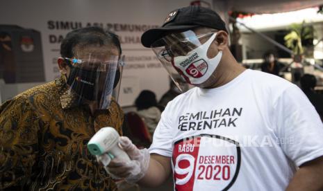 Ketua KPU Arief Budiman (kanan) berbincang dengan Ketua Bawaslu Abhan (kiri) saat meninjau simulasi pemungutan suara pemilihan serentak 2020 di Jakarta, Rabu (22/7/2020). Simulasi tersebut digelar untuk memberikan edukasi kepada masyarakat terkait proses pemungutan dan penghitungan suara Pilkada serentak 2020 yang akan dilaksanakan pada 9 Desember 2020 dengan menerapkan protokol kesehatan COVID-19. ANTARA FOTO/Nova Wahyudi/pras.