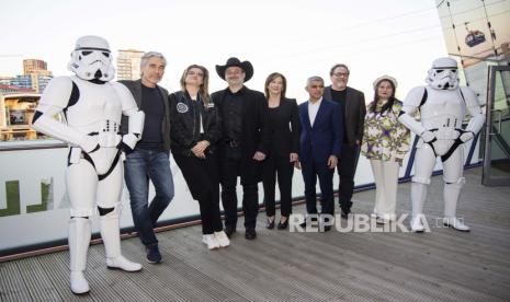 Tony Gilroy, dari kiri, Leslie Headland, Dave Filoni, Kathleen Kennedy, walikota London Sadiq Khan, Jon Favreau dan Sharpen Obaid Chinoy berpose untuk fotografer dalam sesi pemotretan Star Wars Celebration di London, Sabtu, 7 April 2023.