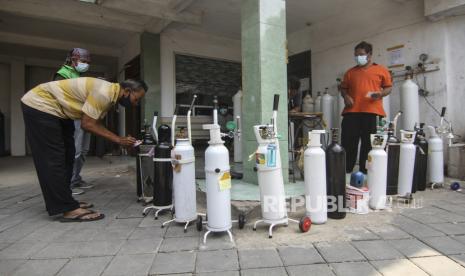 Sejumlah warga menaruh tabung oksigen saat antre isi ulang oksigen 