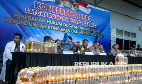 Direktur Reserse Kriminal Khusus Polda Jawa Tengah Kombes Pol Arif Budiman (tengah) bersama tim Satgas Pangan Polda Jawa Tengah menunjukkan barang bukti saat pengungkapan kasus manipulasi volume minyak goreng MinyaKita di PT. Kusuma Mukti Remaja, Jetis, Jaten, Karanganyar, Jawa Tengah, Jumat (14/3/2025). Tim Satgas Pangan Polda Jawa Tengah menyita sebanyak 89.856 botol kemasan MinyaKita produksi PT. Kusuma Mukti Remaja yang melanggar aturan perlindungan konsumen dan metrologi legal dimana volume isi minyak goreng tidak sesuai dengan yang tercantum pada kemasan. 