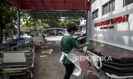 Tenaga kesehatan melakukan disinfeksi tempat tidur pasien di depan Instalasi Gawat Darurat RSUD Cibabat, Jalan Jend H Amir Machmud, Kota Cimahi, Rabu (30/6). Rumah Sakit Umum Daerah (RSUD) Cibabat menutup sementara ruang Instalasi Gawat Darurat (IGD) akibat terus meningkatnya jumlah tenaga kesehatan dan pegawai yang terkonfirmasi positif Covid-19 serta menipisnya ketersediaan oksigen medis di rumah sakit tersebut. Foto: Republika/Abdan Syakura