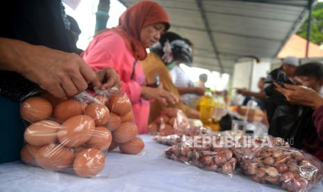 Masyarakat membeli kebutuhan bahan pokok saat pasar murah. Capres Ganjar Pranowo berharap pemerintah mengintervensi harga bahan pokok.