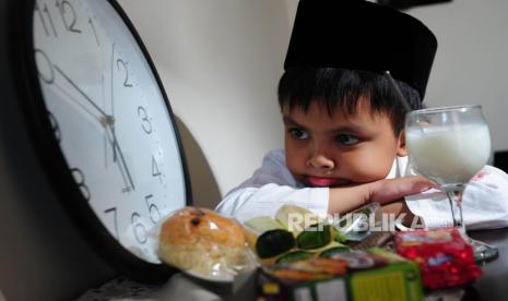 Anak menunggu waktu berbuka puasa (Ilustrasi). Beri pengertian kepada anak bahwa inti dari puasa memang menahan lapar dan haus.