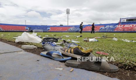 Sepatu dan sandal yang tertinggal saat kerusuhan dan injak-injak pertandingan sepak bola terlihat di lapangan Stadion Kanjuruhan Malang, Jawa Timur, Indonesia, 03 Oktober 2022. Kapolri Jenderal Listyo Sigid Prabowo mengumumkan bahwa setidaknya 125 orang, termasuk polisi, tewas setelah polisi Indonesia menembakkan gas air mata untuk menghentikan penggemar sepak bola memasuki lapangan menyebabkan kepanikan dan injak-injak, menyusul pertandingan antara Arema FC dan Persebaya Surabaya di Jawa Timur pada 01 Oktober. Persatuan Sepak Bola Seluruh Indonesia menghentikan sementara kompetisi Liga 1 2022/2023 selama satu minggu, dan melarang Arema FC menjadi tuan rumah selama sisa kompetisi musim ini. Ribuan Siswa di Tulungagung Sholat Gaib untuk Korban Tragedi Kanjuruhan