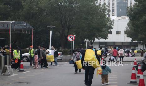 Sejumlah orang tua menjemput anaknya sepulang dari sekolah di Kota Wuhan, Provinsi Hubei, China, Jumat (20/11/2020). Mulai TK hingga perguruan tinggi di kota tempat ditemukannya kasus pertama COVID-19 itu sudah menggelar kegiatan belajar dan mengajar di kelas seperti biasanya setelah tidak ditemukan kasus positif dalam beberapa bulan terakhir. 