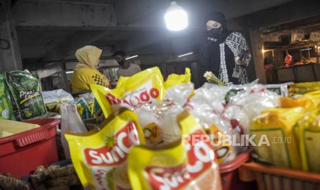 Pedagang minyak goreng melayani pembeli di kiosnya di Pasar Kosambi, Kota Bandung, Senin (30/1/2023). 