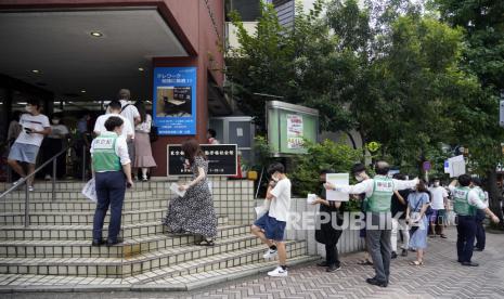 Anak-anak muda berbaris untuk memasuki tempat vaksinasi COVID-19 di distrik Shibuya di Tokyo, Jepang, 29 Agustus 2021. Uang bantuan Covid-19 untuk rumah tangga berpenghasilan rendah di sebuah kota kecil di Jepang Abu secara keliru ditransfer hanya ke satu rekening bank penduduk saja.