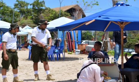 Petugas Satuan Polisi Pamong Praja (Satpol PP) Pariwisata Kabupaten Badung berbincang dengan wisatawan saat hari pertama bertugas di Pantai Kuta, Badung, Bali, Kamis (8/2/2024). Sekitar 70 orang petugas Pol PP Khusus Pariwisata yang baru dibentuk di Bali mulai ditugaskan di berbagai destinasi pariwisata Pulau Dewata untuk menjaga kondusifitas keamanan dan kenyamanan serta memberikan informasi bagi para wisatawan. 