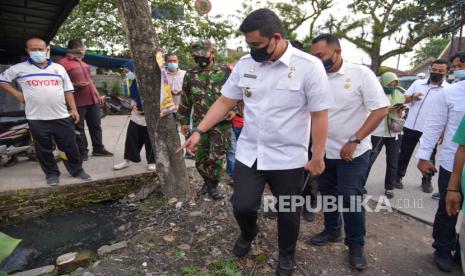 Wali Kota Medan Bobby Nasution (tengah) meninjau saluran drainase yang bermasalah di Jalan Sunggal, Medan, Sumatera Utara, Rabu (16/06/2021). Peninjauan tersebut sebagai respon terhadap keluhan warga yang mengeluhkan saluran drainase di kawasan tersebut tersumbat dan mengakibatkan banjir jika hujan turun. 