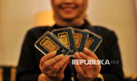 Model menunjukkan replika emas batangan BSI saat peluncuran BSI Gold di Jakarta, Kamis (28/11/2024).