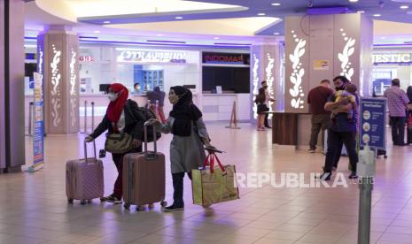 Calon penumpang melintas di depan konter tiket kapal feri tujuan Malaysia dan Singapura di Pelabuhan Internasional Batam Centre, Kota Batam, Provinsi Kepulauan Riau, Senin (11/4/2022). 