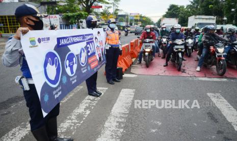 Petugas Dishub Kota Bandung melakukan sosialisasi protokol kesehatan 3M (Memakai Masker, Menjaga Jarak, dan Mencuci Tangan) dengan membentangkan spanduk, di Jalan pasupati, Kawasan Gasibu, Kota Bandung, Rabu (16/12). Sosialisasi protokol kesehatan pencegahan Covid-19 terus dilakukan banyak pihak, menyusul kembali meningkatnya kasus positif Covid-19 di masyarakat.