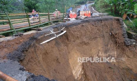 Pengendara sepeda motor melintasi jembatan darurat di lokasi tanah longsor Desa Lumajang, Watumalang, Wonosobo, Jawa Tengah, Jumat (17/10/2022). Tanah longsor akibat hujan deras mengakibatkan jalan antarkecamatan terputus sehingga warga membuat jembatan darurat yang hanya bisa dilalui sepeda motor dan pejalan kaki. 