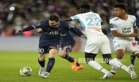 Pemain PSG Lionel Messi, kiri, berduel memperebutkan bola dengan pemain Marseille Pape Gueye, tengah, dan pemain Marseille Boubacar Kamara selama pertandingan sepak bola League One antara Paris Saint Germain dan Marseille, di stadion Parc des Princes, di Paris, Prancis, Ahad, 17 April , 2022.