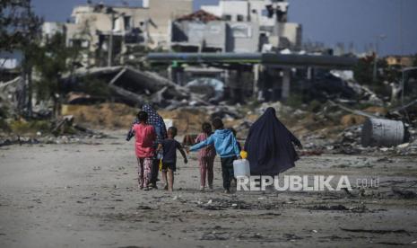 Pengungsi Palestina berjalan di samping bangunan yang hancur di Khan Younis, Jalur Gaza Selatan, Rabu (5/6/2024). Menurut Kementerian Kesehatan Palestina dan Pasukan Pertahanan Israel (IDF), sejak militan Hamas melancarkan serangan terhadap Israel dari Jalur Gaza pada 07 Oktober 2023, dan operasi Israel di Gaza dan Tepi Barat  tercatat Lebih dari 36.000 warga Palestina dan lebih dari 1.400 warga Israel terbunuh. EPA-EFE/MOHAMMED SABER