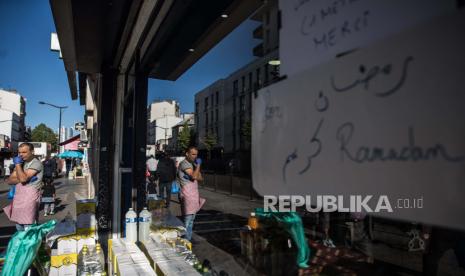 Tulisan Ramadan Kareem terpasang di toko kue Aljazair disaat sebelum waktu berbuka puasa di pasar Arab daerah Porte de Montreuil di Paris, Prancis, Ahad (26/4). Mayoritas penduduk di sekitar daerah Porte de Montreuil, Paris adalah Muslim Arab dari Utara Afrika, Muslim di seluruh Prancis pada tahun ini tidak dapat mengikuti kegiatan berdoa dan beribadah bersama akibat ditutupnya masjid karena pandemi COVID-19