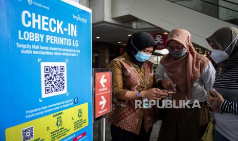 Petugas membantu calon pengunjung untuk mengakses aplikasi PeduliLindungi sebelum memasuki mal, di Mal Tangcity, Kota Tangerang, Banten, Jumat (20/8/2021). Pemerintah Kota Tangerang kembali membuka pusat perbelanjaan dengan membatasi jumlah pengunjung sebanyak 50 persen dari total kapasitas dan harus melakukan skrining melalui aplikasi PeduliLindungi sebelum memasuki pusat perbelanjaan. 