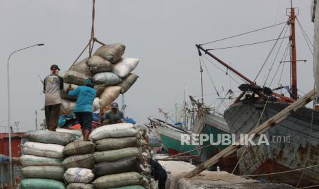  Pekerja memuat kantong pupuk ke perahu kayu di pelabuhan Sunda Kelapa di Jakarta, 10 Mei 2022. Presiden Bank Dunia David Malpass pada Rabu (25/5/2022) menyatakan bahwa perang Rusia di Ukraina yang memberikan dampak terhadap harga-harga pangan dan energi, serta ketersediaan pupuk, dapat memicu resesi global.