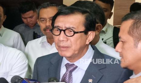 Menteri Hukum dan HAM (Menkumham) Yasonna H Laoly menghampiri kerumunan wartawan, sementara Wamenkumham Edward Omar Sharif Hiariej atau Eddy kabur melalui pintu di belakang Ruang Rapat Komisi III DPR, Kompleks Parlemen, Jakarta, Selasa (21/11/2023). 