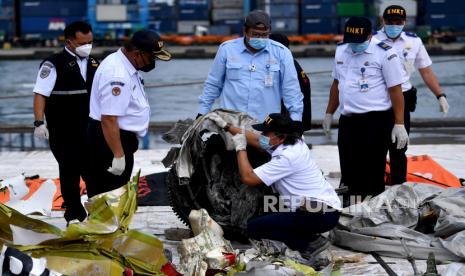 Ketua KNKT Soerjanto Tjahjono (kedua kiri) bersama anggota memeriksa bagian mesin turbin pesawat Sriwijaya Air nomor penerbangan SJ182 rute Jakarta-Pontianak pada hari kelima operasi SAR pesawat tersebut di Dermaga JICT, Tanjung Priok, Jakarta Utara, Rabu (13/1/2021). 